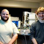Dominic Scognamiglio and Angus Gale in front of an optical bench