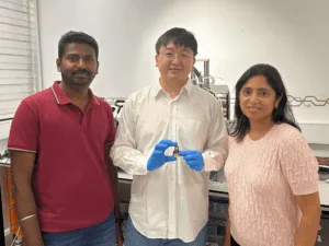 Dr Shanmuga Sundar Dhanabalan, Mingije Yang and Professor Madhu Bhaskaran standing in a lab holding a sensor