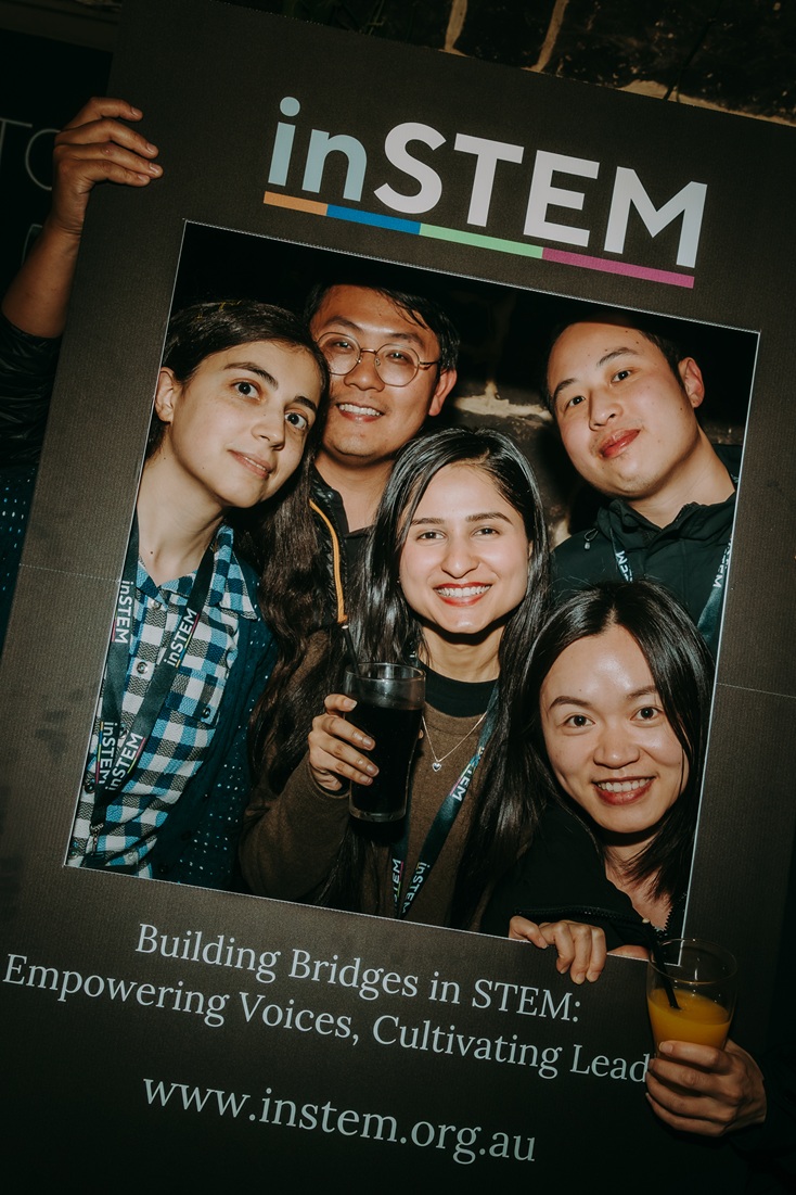 a group of people similing and holding a banner that says